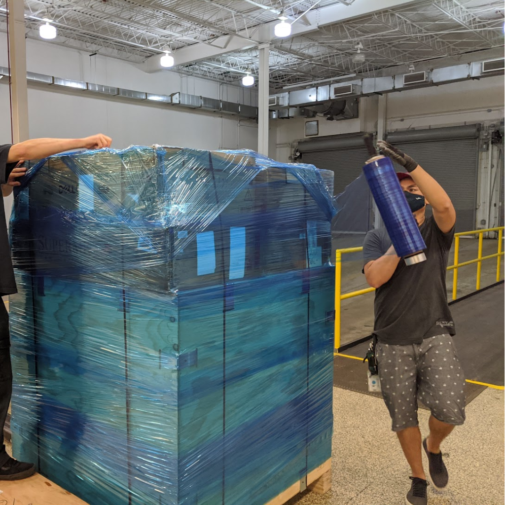 A Summit technician shrink-wrapping a pallet of equipment for shipment